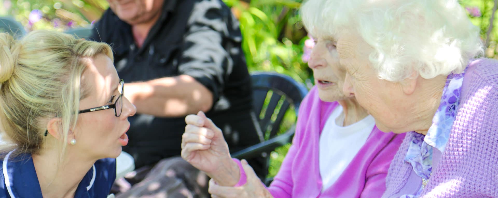 Laurel Care Home nurse helping two residents in the garden